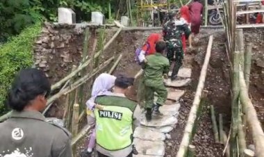 Babinsa Bantu Anak Sekolah Lewati Jembatan Yang Putus