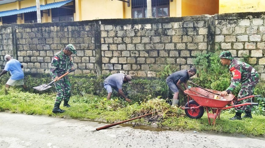 Babinsa dan Masyarakat Bersihkan Drainase Menuju Dermaga Waiya