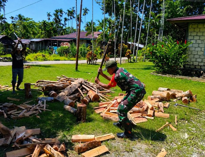 Pengabdian Tanpa Batas Babinsa Koramil Demta Turun Langsung Bantu Warga Belah Kayu Bakar
