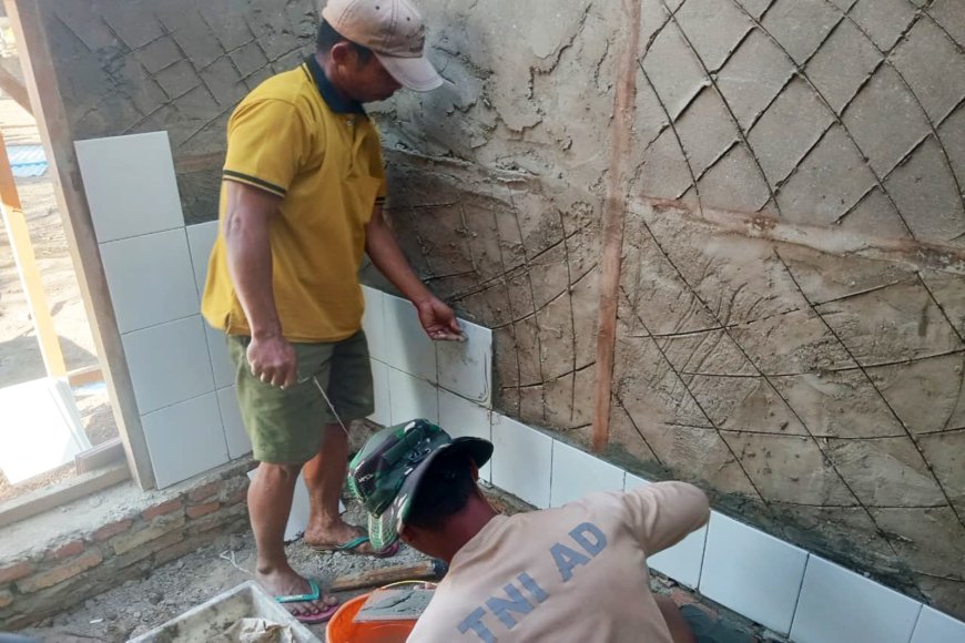 Pemasangan Dinding Keramik, Personel Satgas TMMD Percepat Pembangunan MCK di Wanam Merauke